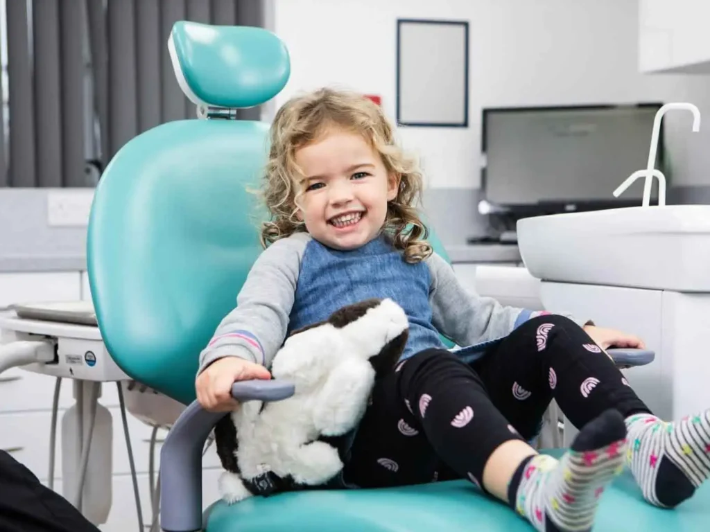 Smiling child sitting in dentist chair